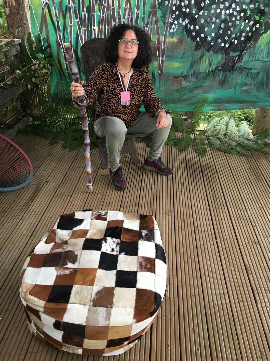 A guest seated with a cane, beside a cowhide pouf