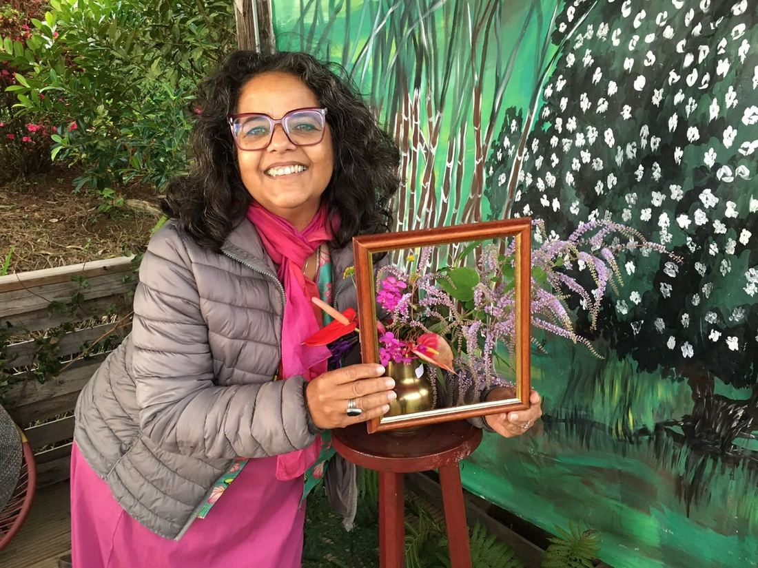 A guest holding a small framed floral piece