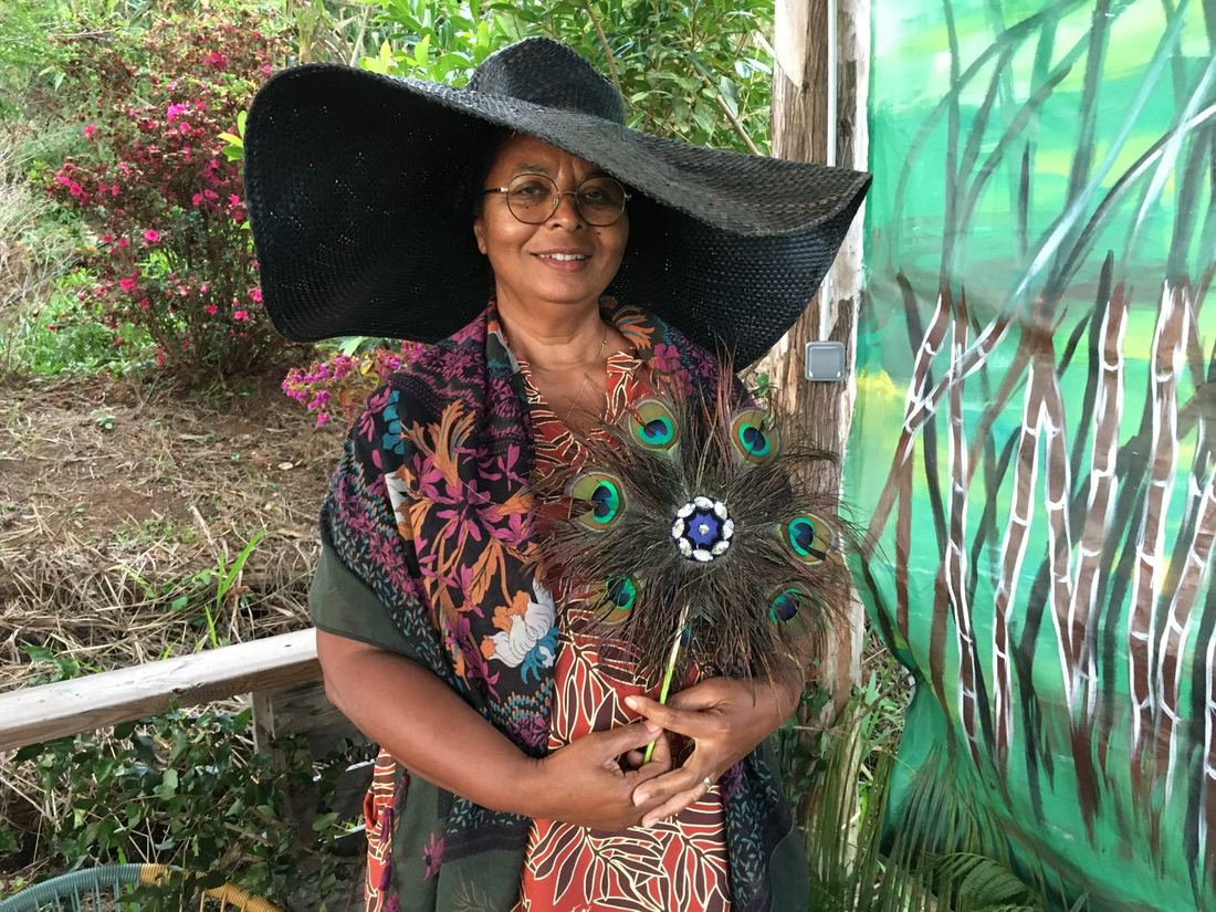A guest in a wide-brimmed hat and a peacock-print shawl