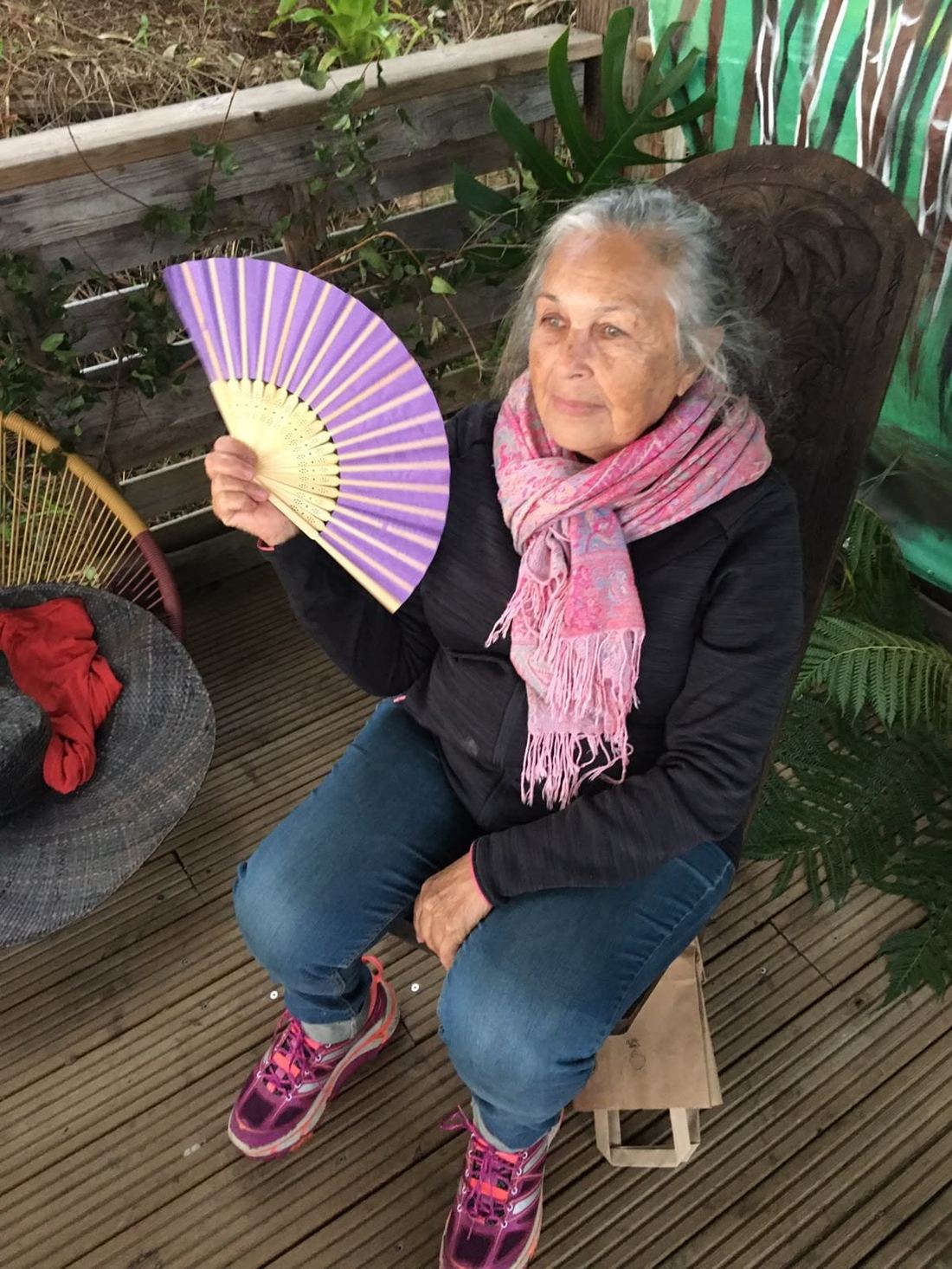 A guest with a fan, seated at the market