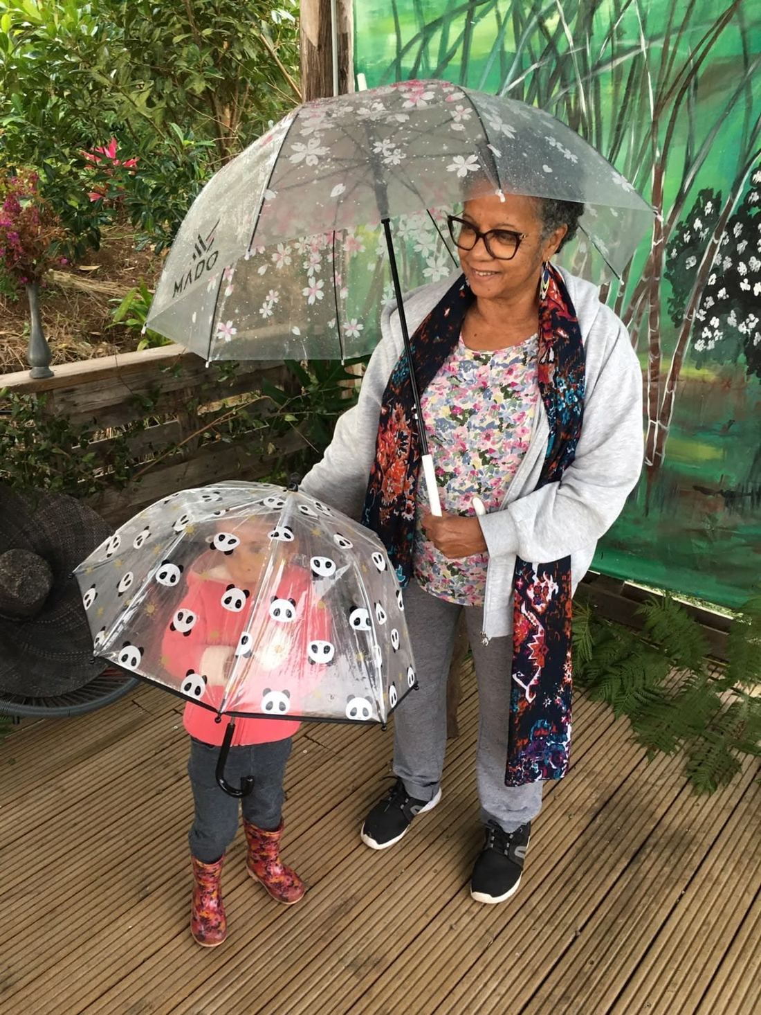 Guests sheltering under umbrellas on a rainy market day